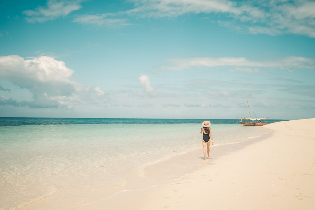 Chica andando por un camino de arena en la playa